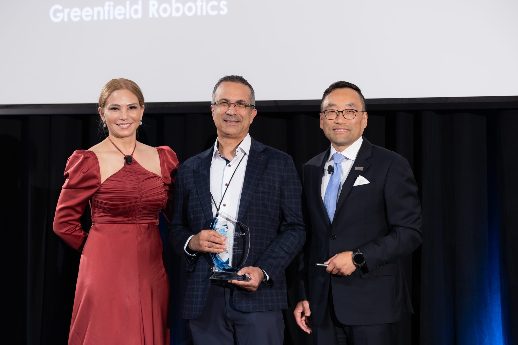 An award presentation on stage at a corporate leadership dinner