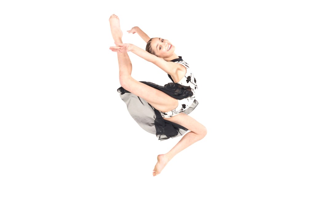 A young dancer caught mid-leap on a white background